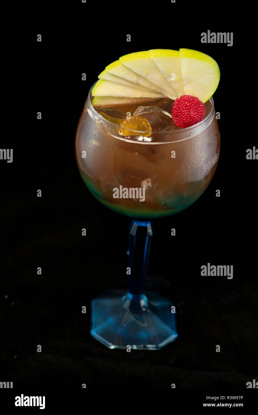 Speciale tè ghiacciato cocktail con coke, rum leggero, curacao blu e dolce e aspro isolato con sfondo nero Foto Stock