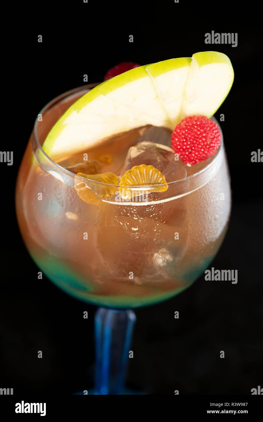Speciale tè ghiacciato cocktail con coke, rum leggero, curacao blu e dolce e aspro isolato con sfondo nero Foto Stock