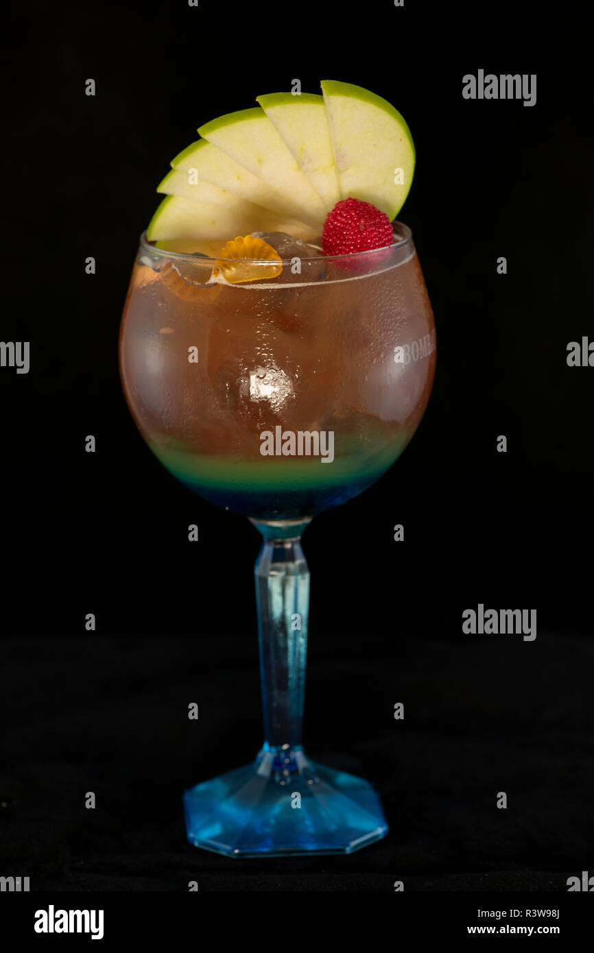 Speciale tè ghiacciato cocktail con coke, rum leggero, curacao blu e dolce e aspro isolato con sfondo nero Foto Stock