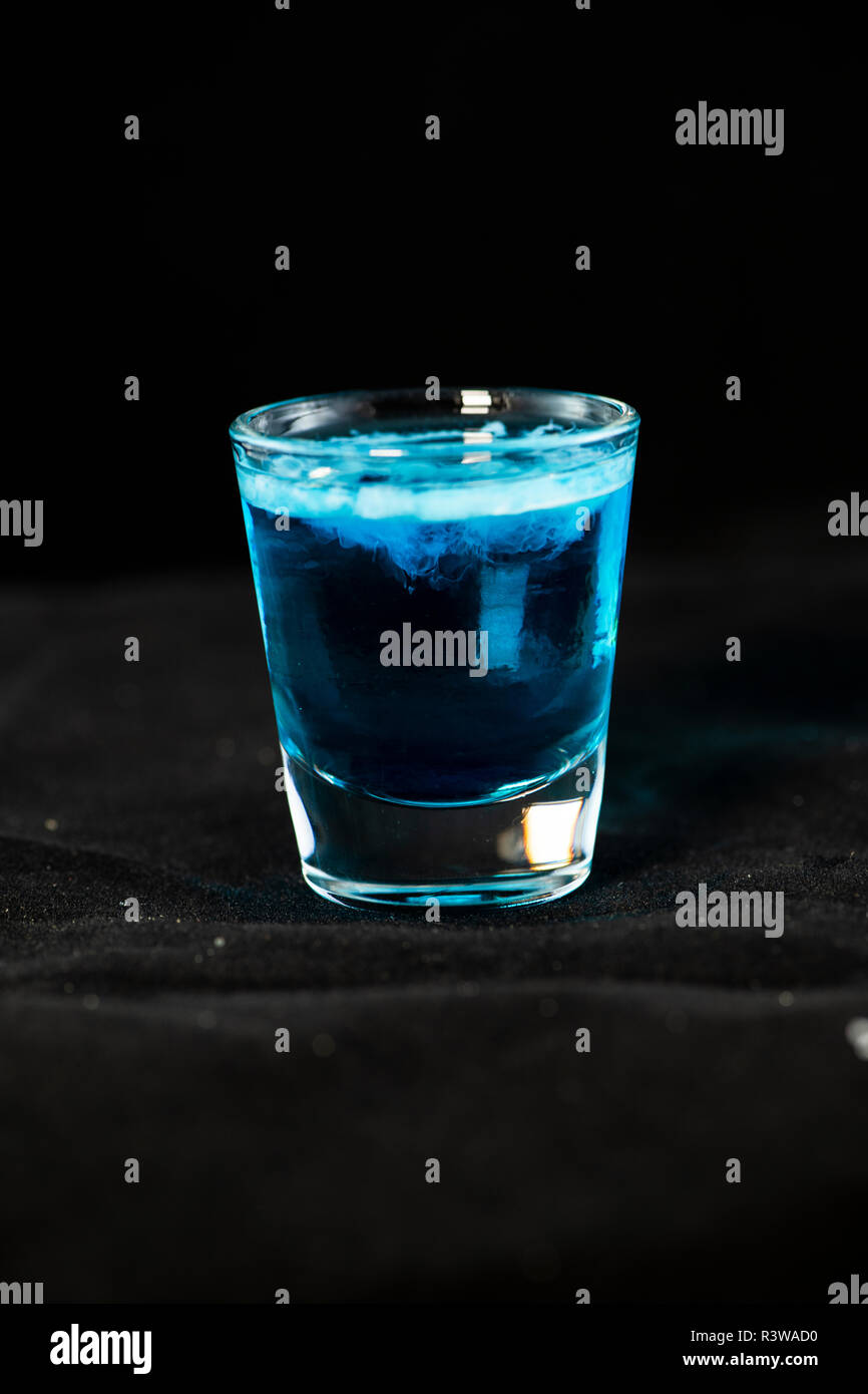 Medusa shot cocktail con curacao blu, sambuca, vodka e latte isolate con sfondo nero Foto Stock