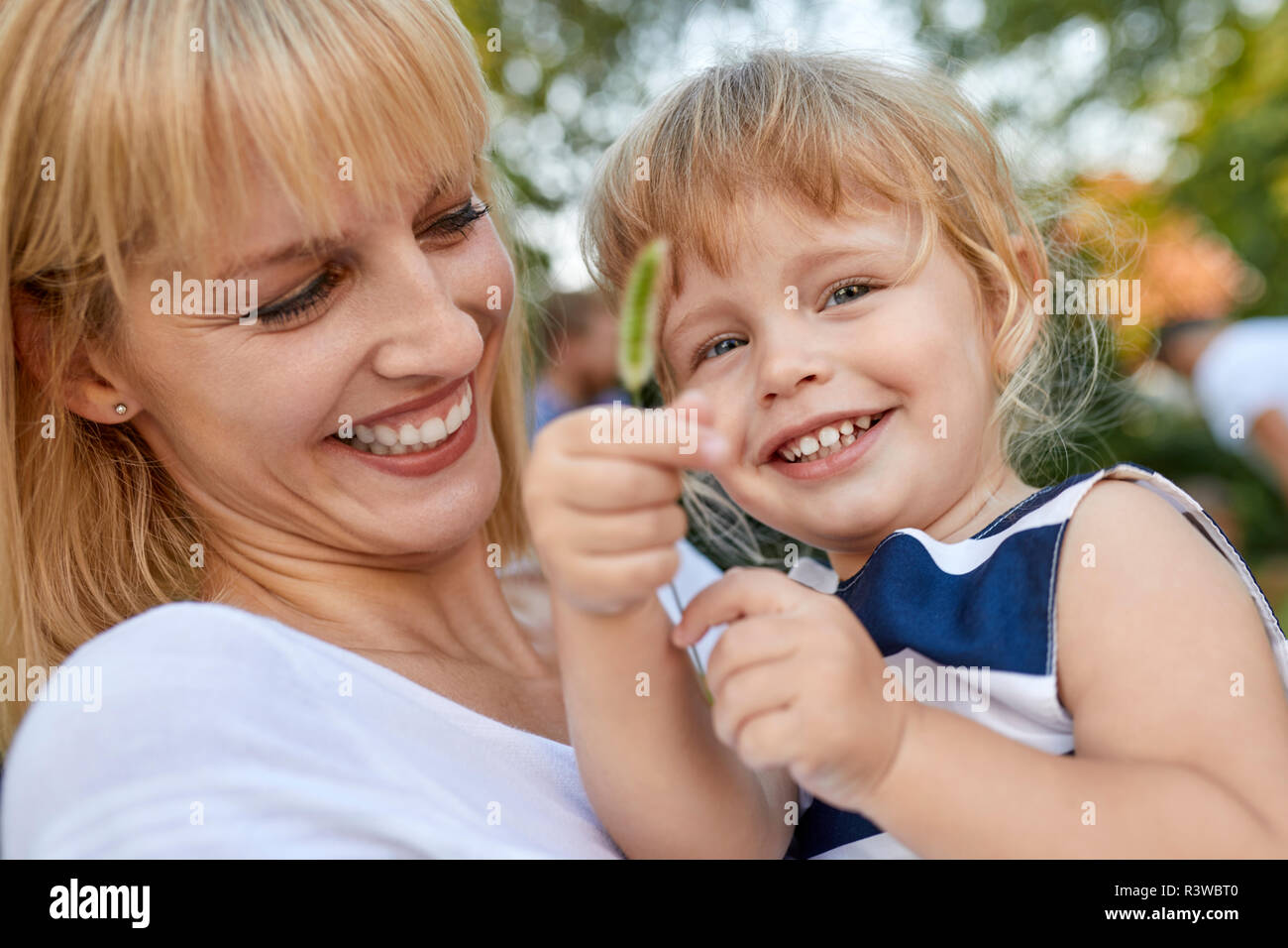 Felice madre con sua figlia in possesso di una levetta all'aperto Foto Stock