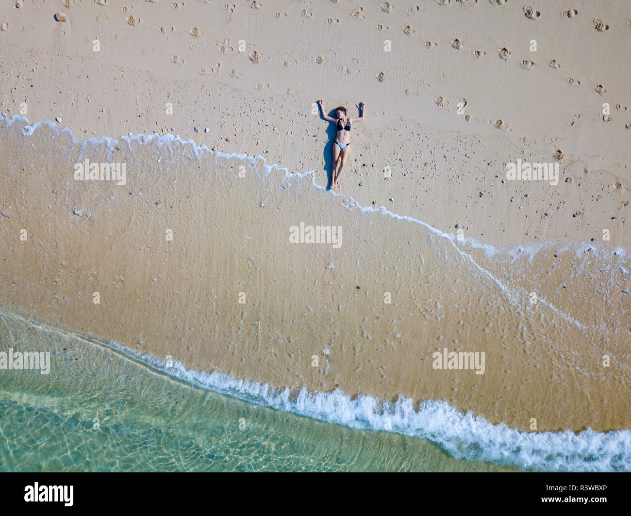 Indonesia, Bali, Melasti, vista aerea del Karma Kandara beach, donna sdraiata sulla spiaggia Foto Stock