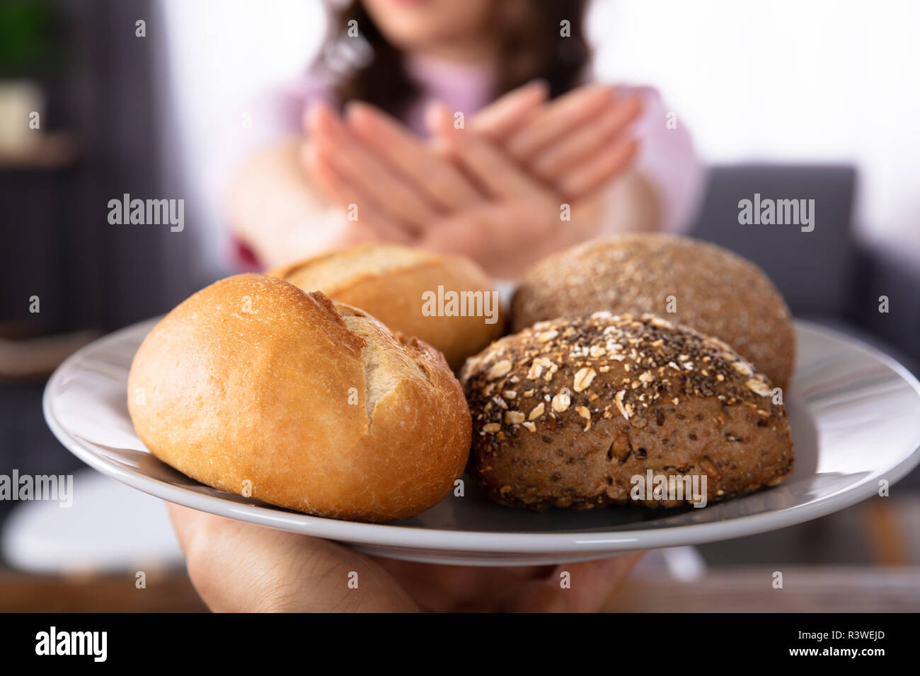 Close-up di una donna di mano rifiutando il pane offerto da persona Foto Stock