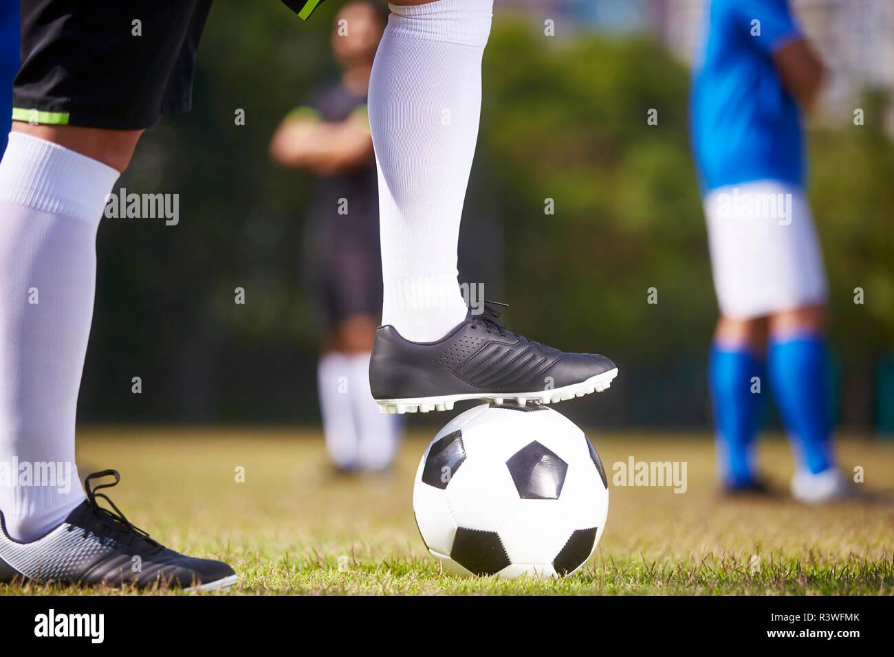 Piede di un giocatore di calcio intensificazione su un campo di calcio pronto per il kick off di un match Foto Stock