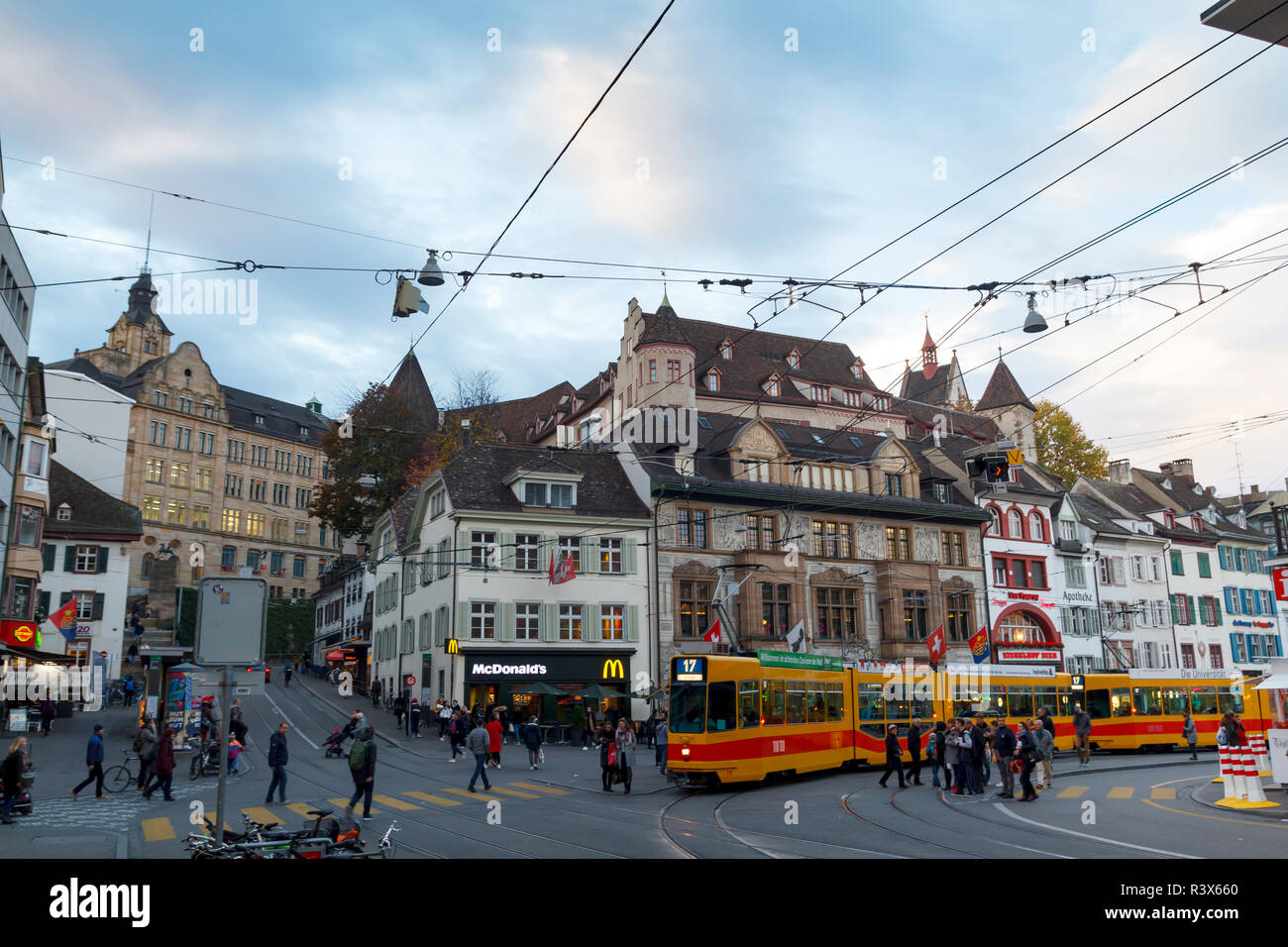 Dal centro città di Basilea e con le persone camminare e tram di fronte case storiche Foto Stock