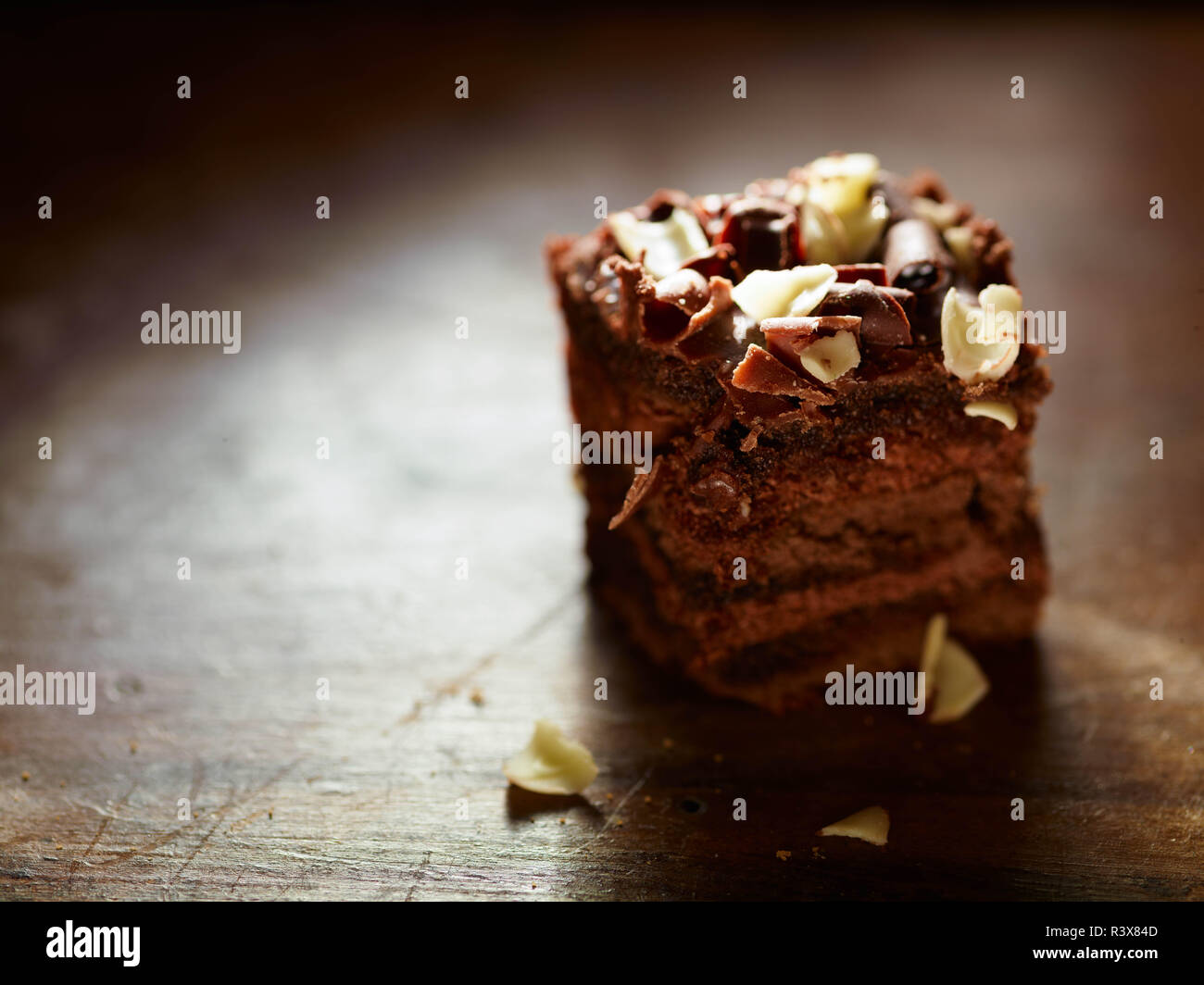 Un primo piano di un delizioso pezzo di torta al cioccolato su un tavolo di legno. Foto Stock