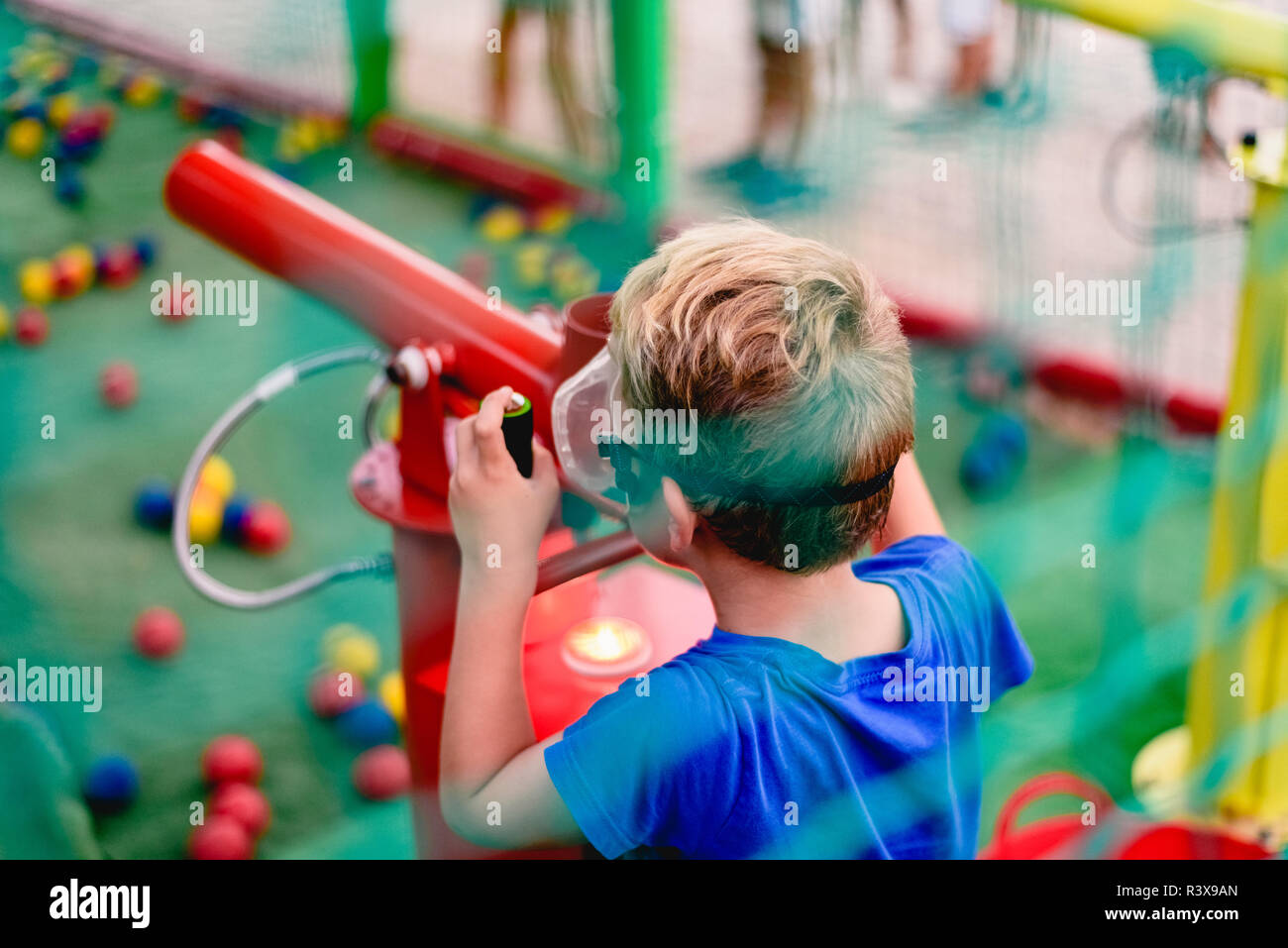 Bambini che giocano a una fiera estiva con un cannone di palline colorate  di aria compressa Foto stock - Alamy