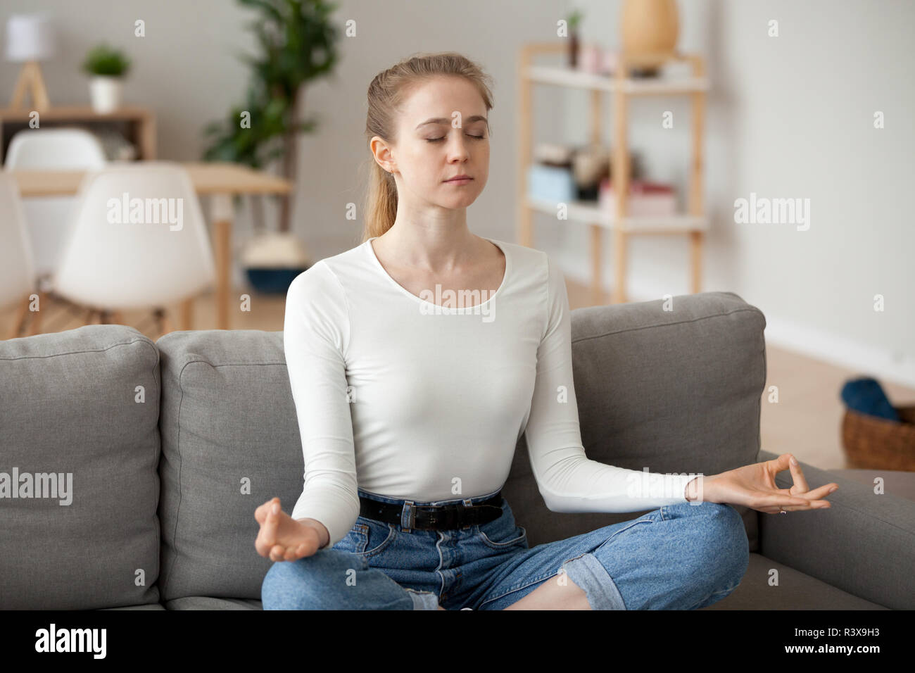 Femmina calma meditando la pratica dello yoga a casa il lettino Foto Stock