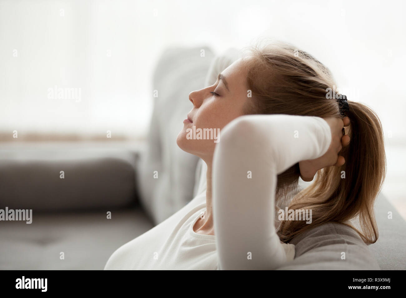 Calma giovane femmina rilassarvi sul lettino a casa Foto Stock