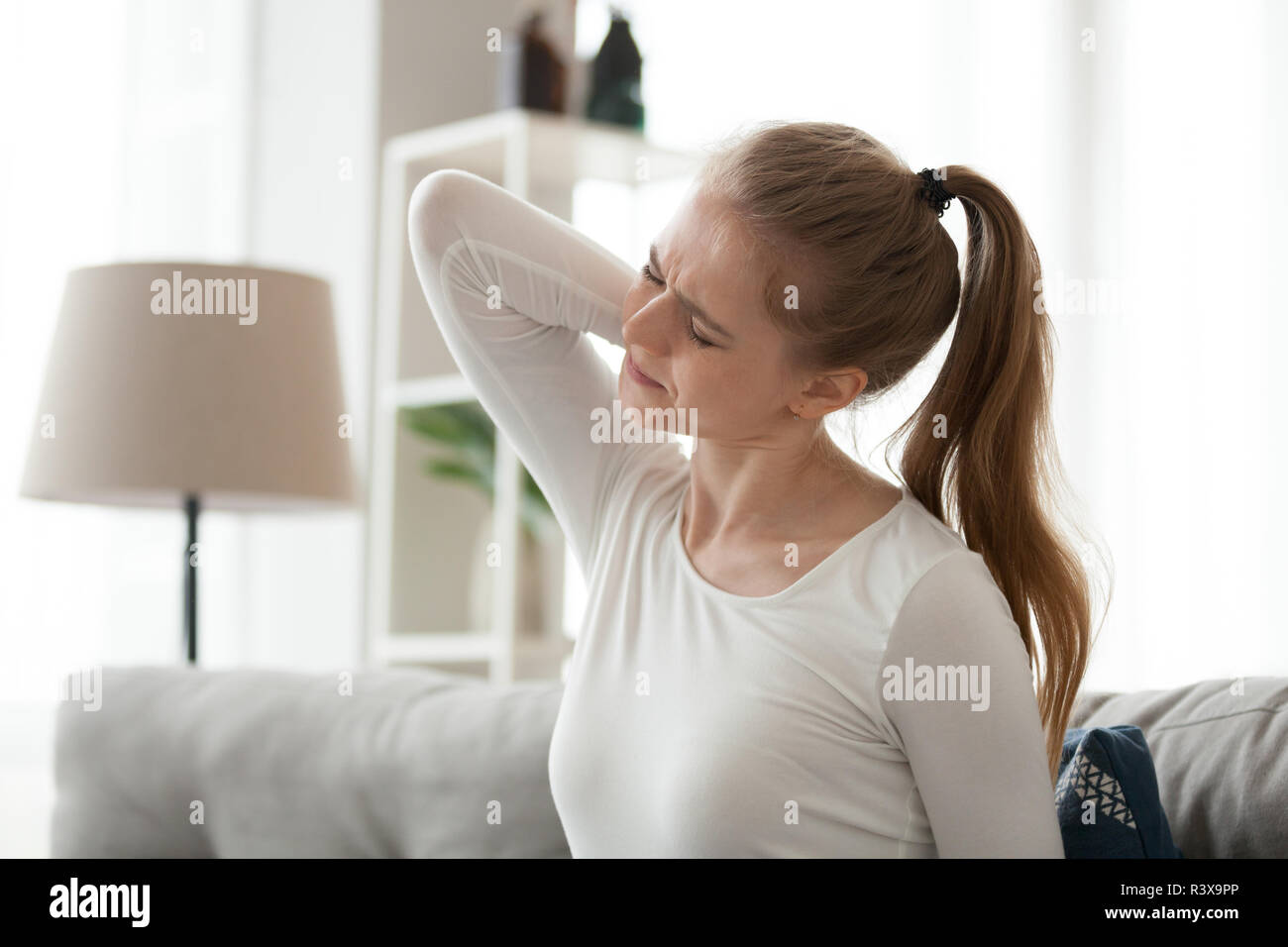 Stanco di sesso femminile soffre di dolori alla schiena a casa Foto Stock