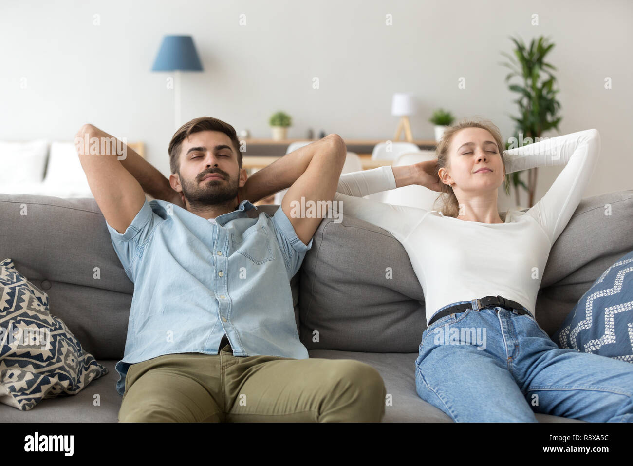 Calma il marito e la moglie rilassarvi sul lettino le mani sopra la testa Foto Stock