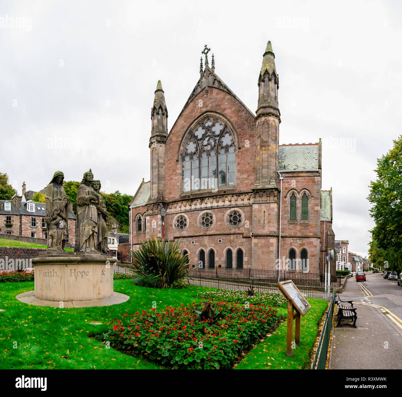Una vista di Ness Bank chiesa con una composizione di fede, di speranza e di carità statue di fronte ad esso in un piccolo giardino, Inverness, Scotland Foto Stock