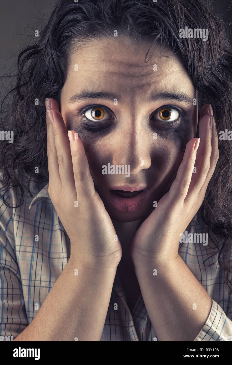 Close-up di una giovane donna spaventata con strappo gli occhi macchiati su  sfondo grigio Foto stock - Alamy
