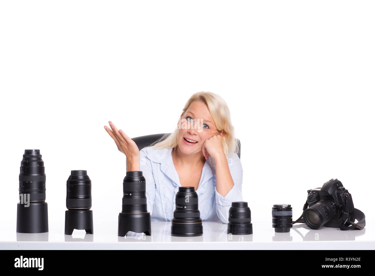 Infastiditi fotografo seduto di fronte a varie lenti Foto Stock