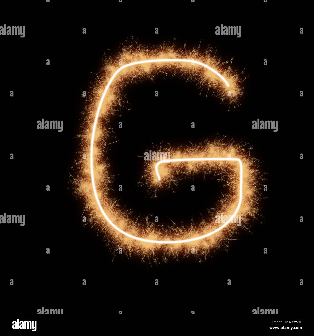 Lettera G di alfabeto scritto da scintille squib su uno sfondo nero. Foto Stock