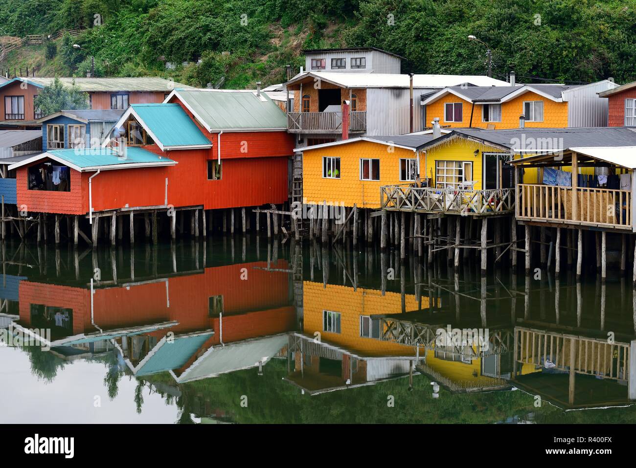 Colorato palafitte, stazioni palafitticole, chiamato palafitos, con acqua riflessione, Castro, isola di Chiloé, Cile Foto Stock