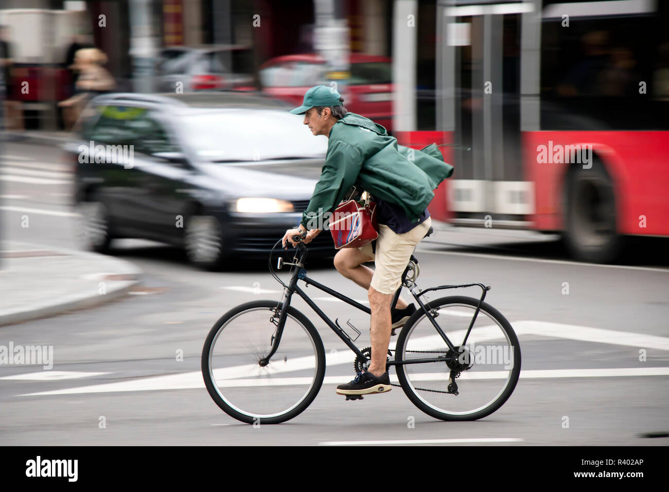 Belgrado, Serbia - Luglio 19, 2018: un uomo maturo equitazione biciclette su strada trafficata , il panning shot Foto Stock
