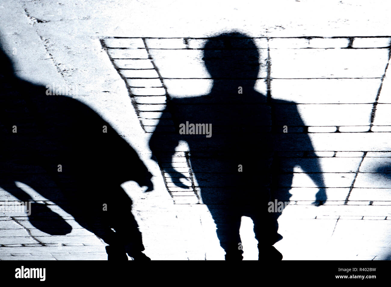 Sfocata silhouette e ombra di due persone a piedi la strada di città di notte Foto Stock