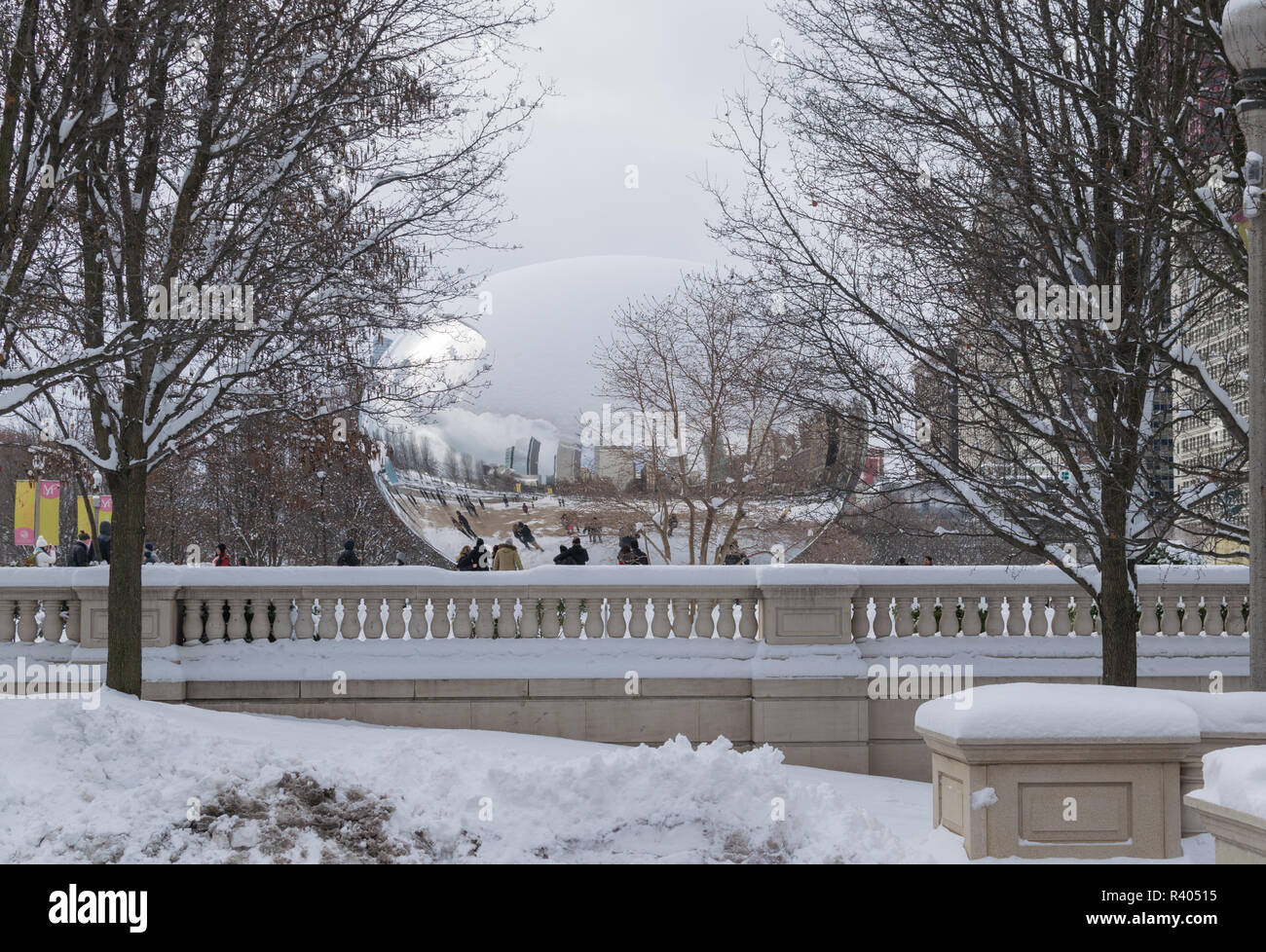 Cloud Gate coperto di neve cercando trasparente, altre mondane, il Millennium Park di Chicago Foto Stock