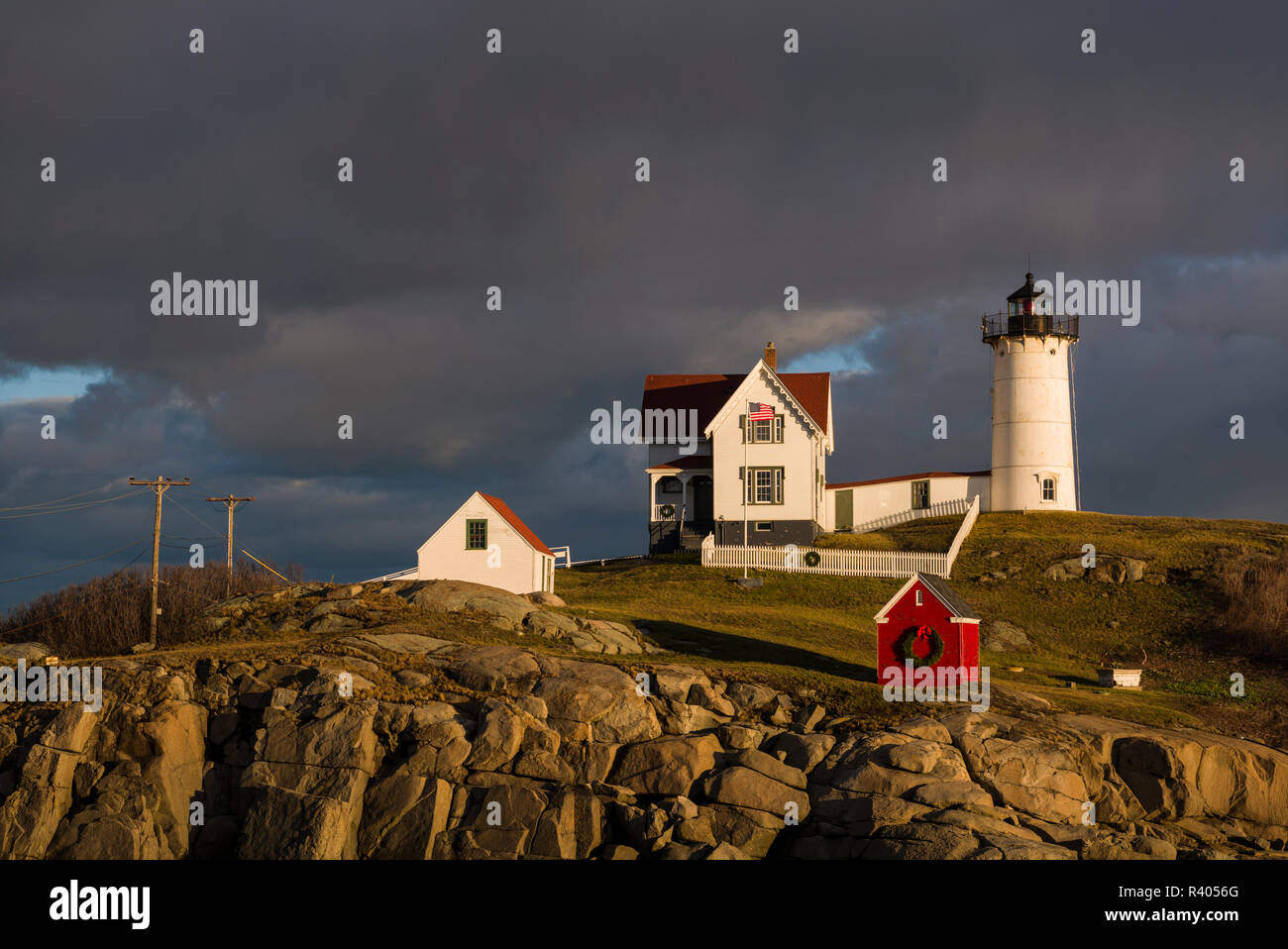 Stati Uniti d'America, Maine, York Beach, Nubble Luce faro con decorazioni di Natale, sunset Foto Stock