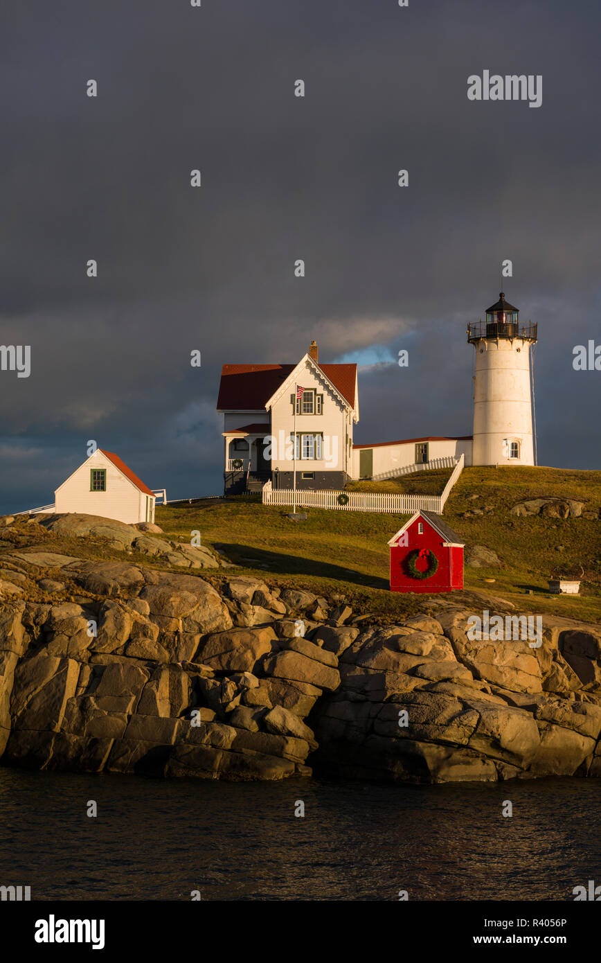 Stati Uniti d'America, Maine, York Beach, Nubble Luce faro con decorazioni di Natale, sunset Foto Stock