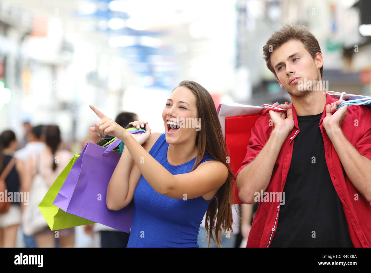 L'uomo annoiato a fare shopping con la sua fidanzata Foto Stock