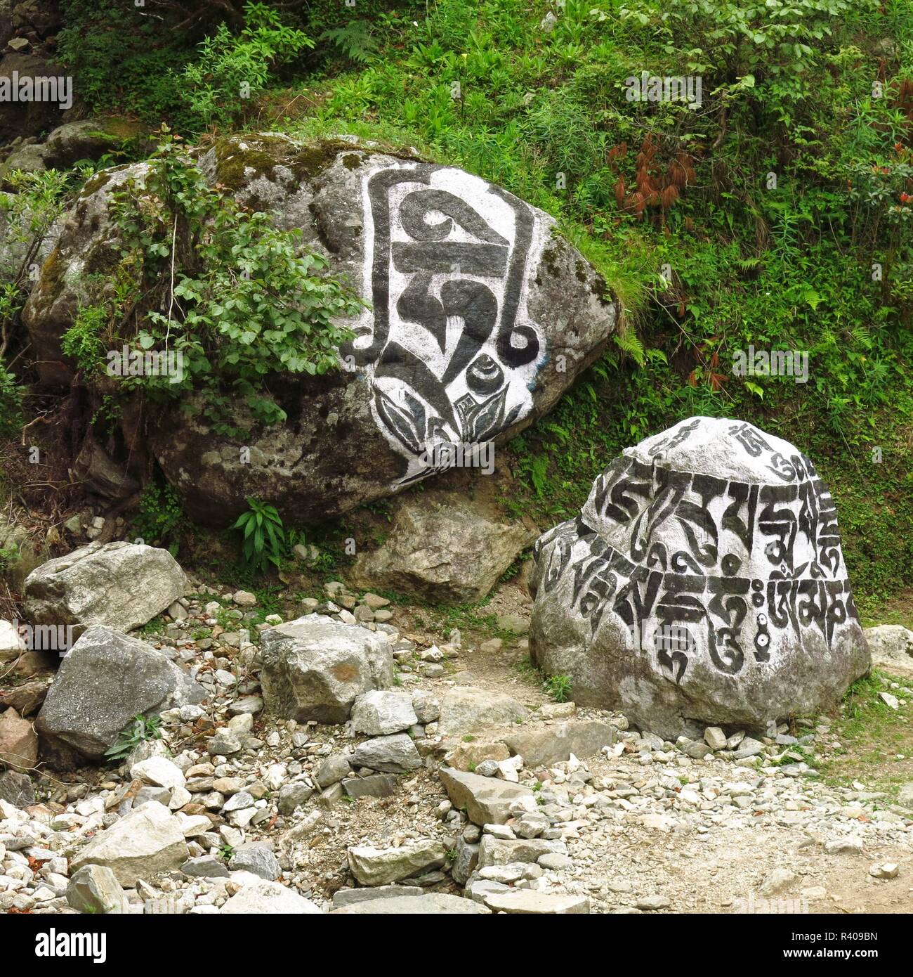 Buddista pietre mani vicino a Lukla. Il monte Everest National Park, Nepal. Pietre con i religiosi iscrizione "OM MANI PADME HUM". Foto Stock