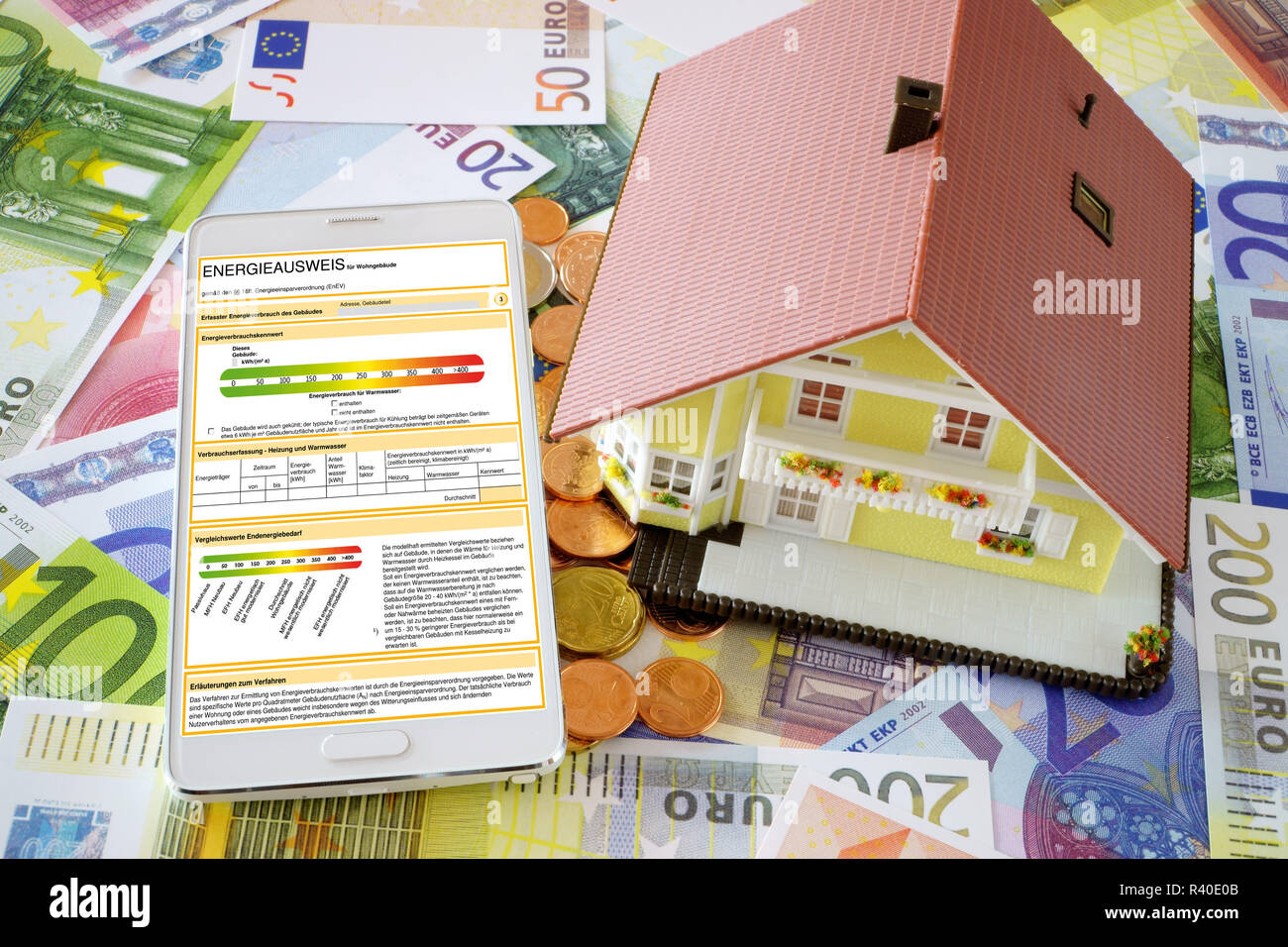 Certificato di rendimento energetico sullo smartphone e un modello di casa Foto Stock