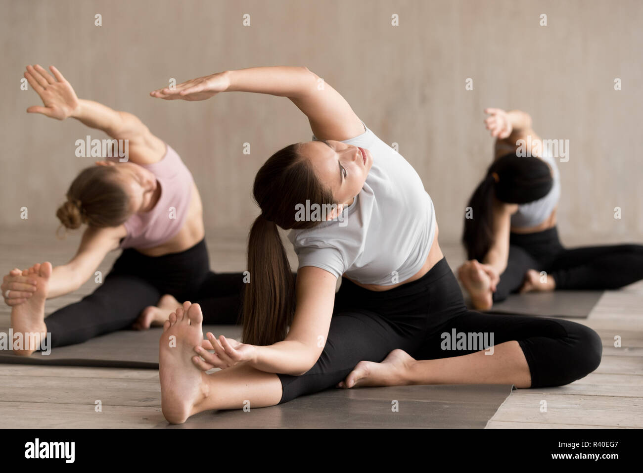 Gruppo di persone che praticano lo yoga, Parivrtta Janu Sirsasana pongono Foto Stock