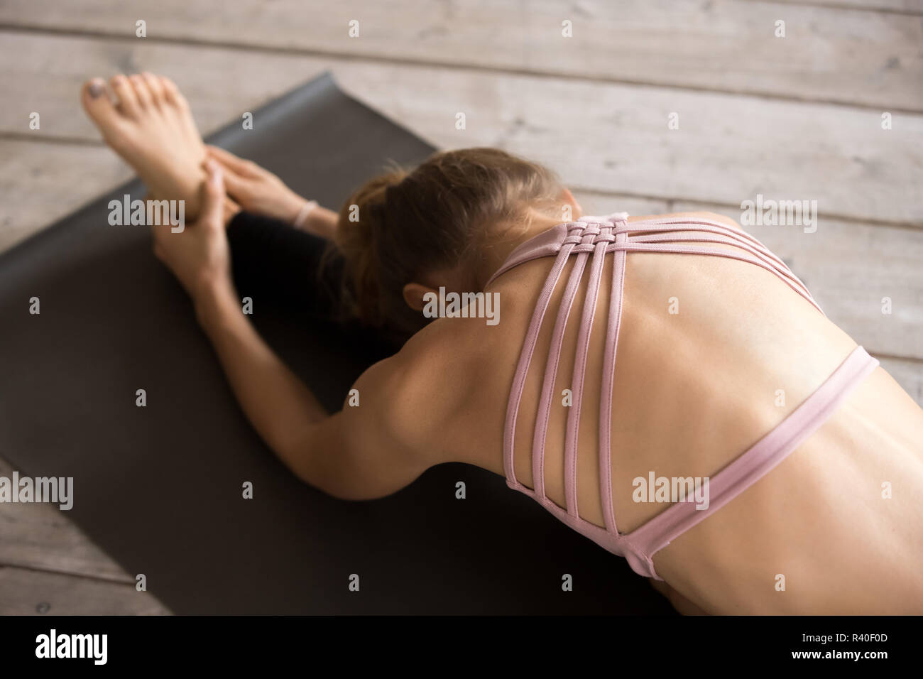 Yogi donna seduto facendo piegare in avanti, close up Foto Stock