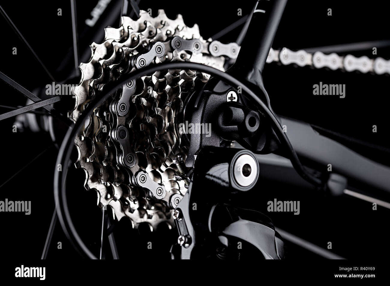 Noleggio bici deragliatore posteriore ingranaggio catena casette dettaglio chiudere up shot nero lo sfondo scuro Foto Stock