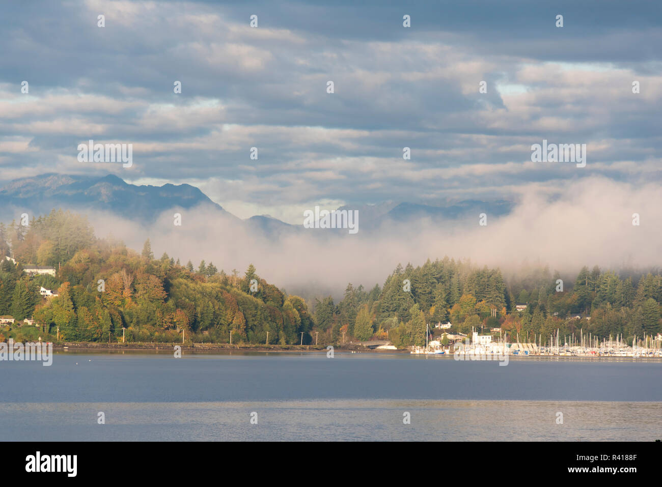 Stati Uniti d'America, nello Stato di Washington. Kitsap penisola e montagne olimpiche con la nebbia e nuvole e sole. Foto Stock