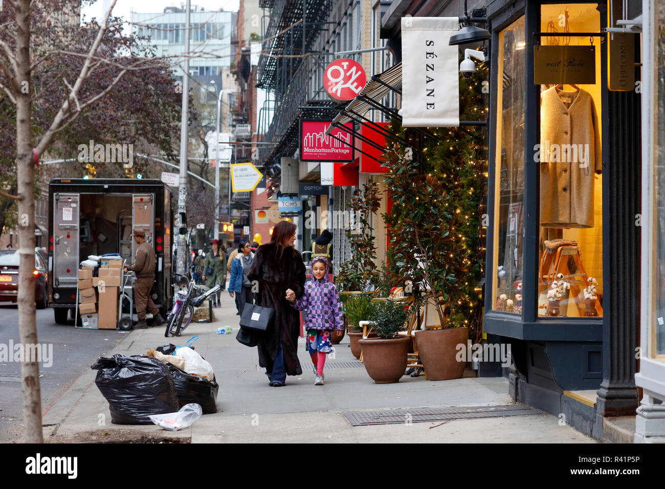 Persone che camminano giù Elizabeth Street con le sue molte piccole boutique e negozi di moda nel Quartiere Nolita di Manhattan, New York, NY Foto Stock