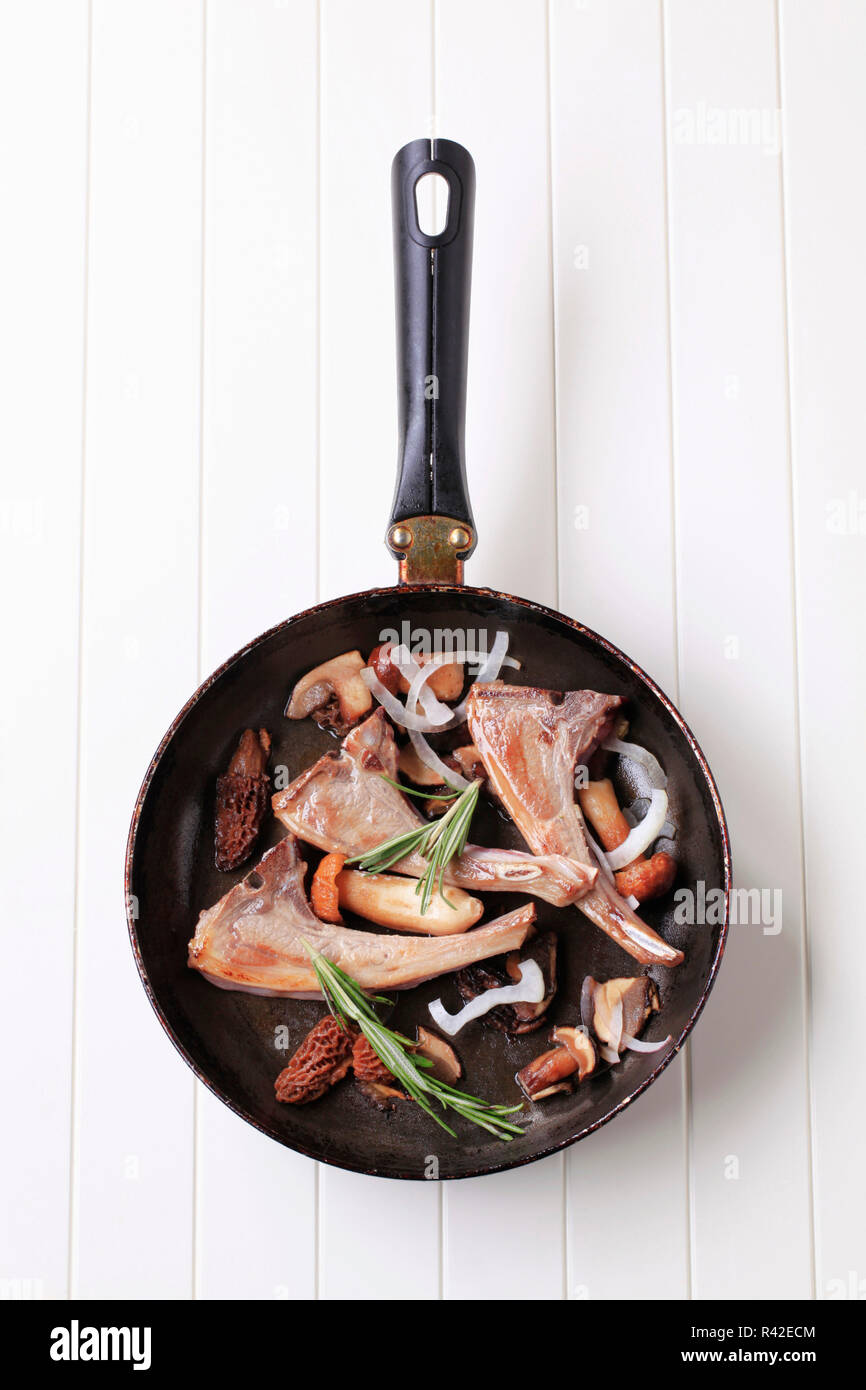 Pan-arrosto costolette di agnello e funghi Foto Stock