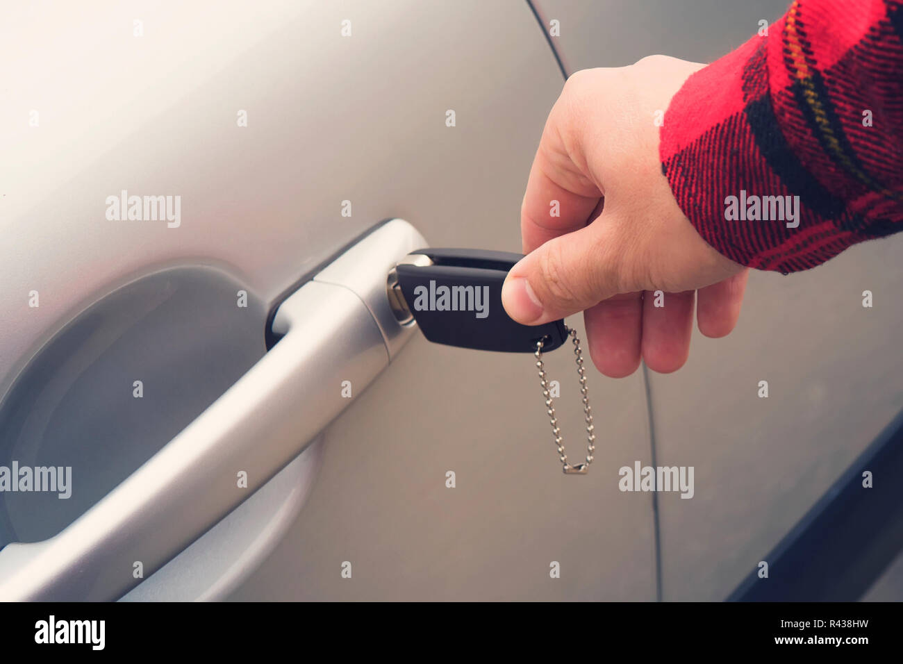 Chiusura del diritto maschio lato ruotando la chiave nel foro sulla vettura porta. L'uomo utilizza la chiave per aprire il nuovo veicolo. Noleggio automobili. Come ottenere la guida Foto Stock