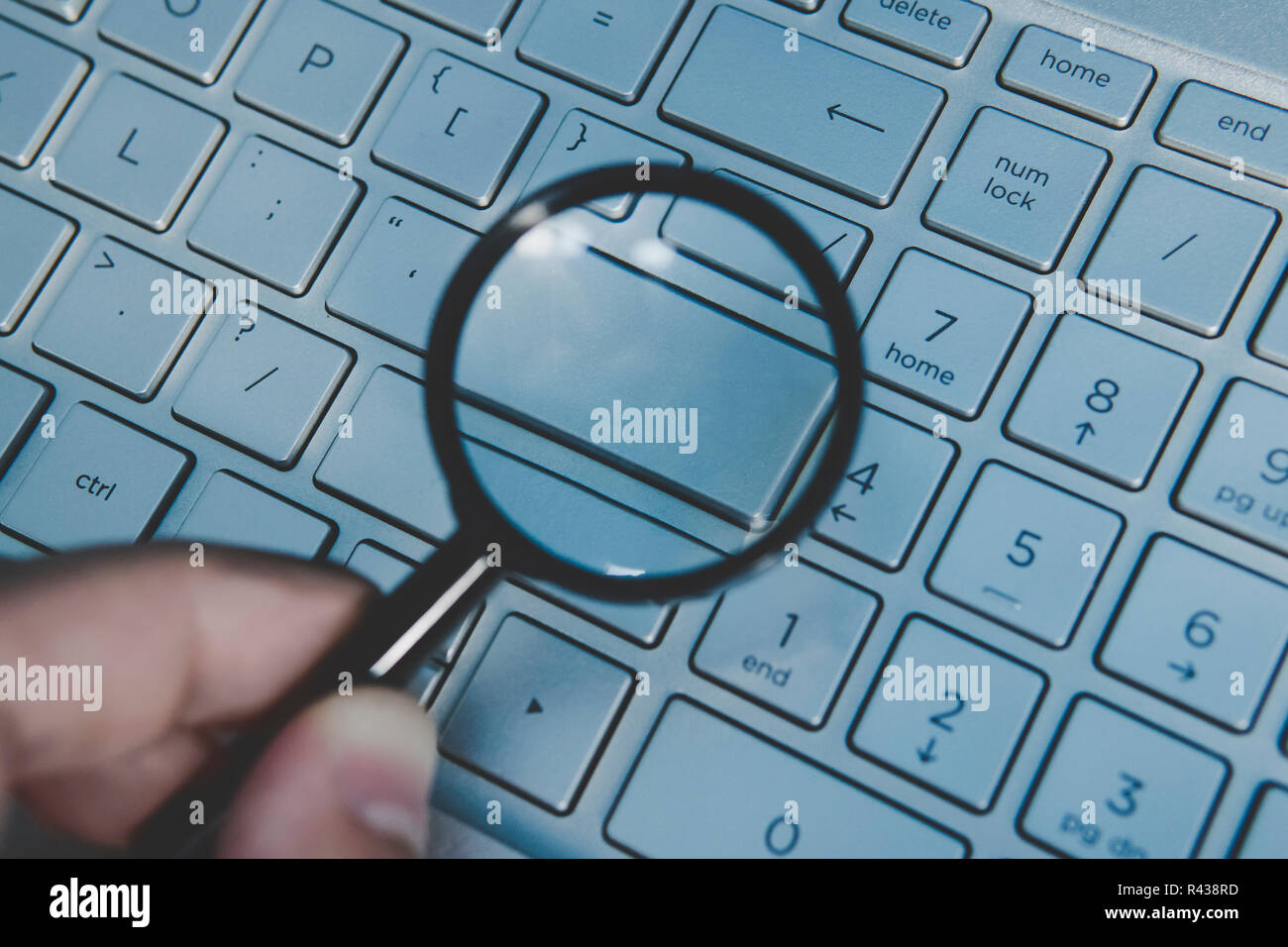 Pulsante vuoto della tastiera portatile magnidied attraverso la lente di ingrandimento. Privi di parole chiave di una tastiera di computer vista attraverso la lente di ingrandimento. Scrivi il tuo testo sulla tastiera del computer. Concetto di navigare in internet. Foto Stock