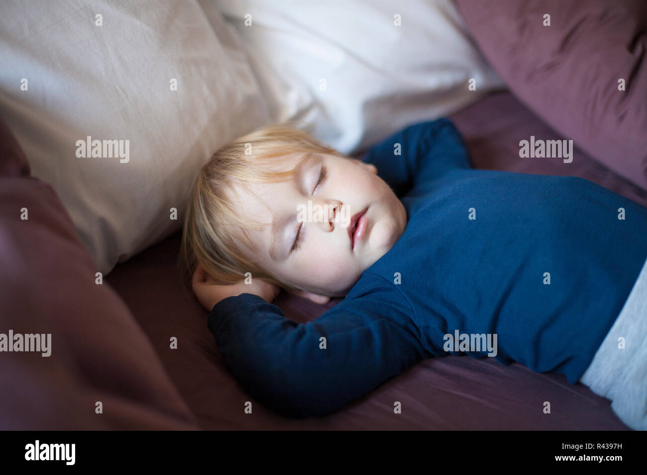 Faccia il bambino dorme tra cuscini Foto Stock