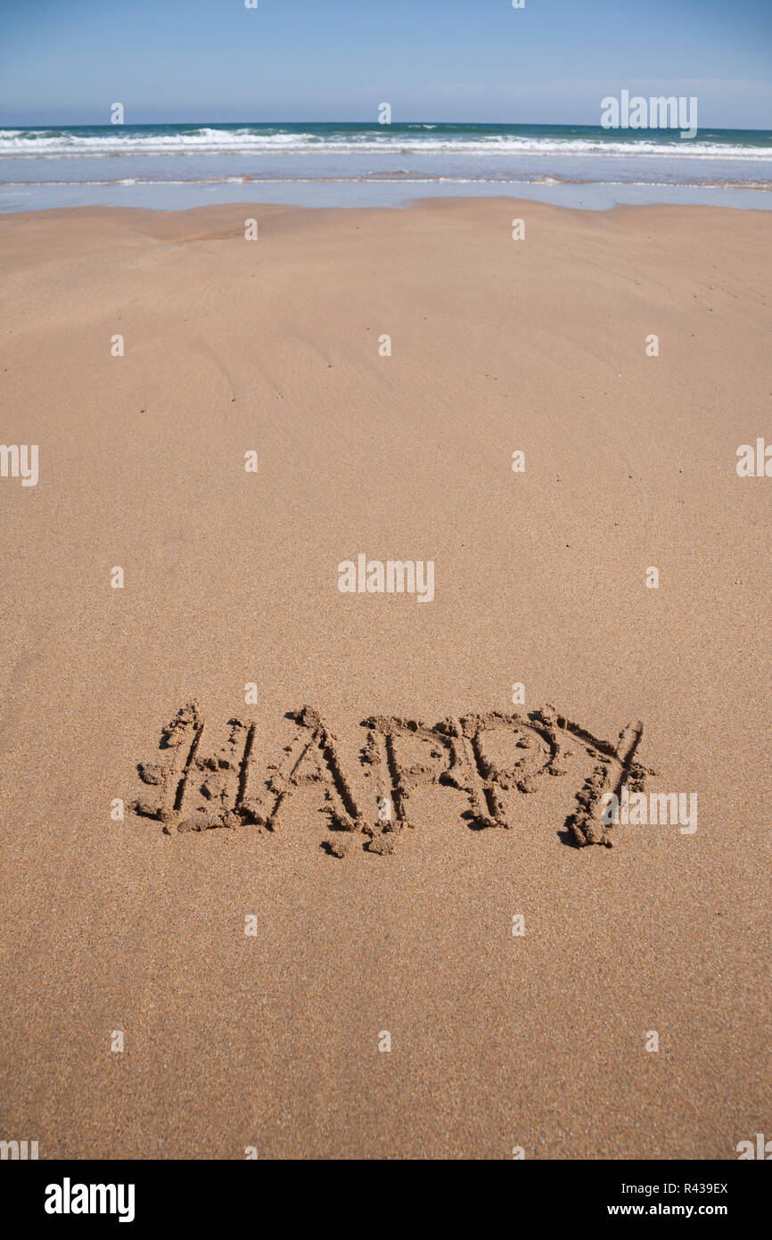 Testo di felice in spiaggia di sabbia Foto Stock