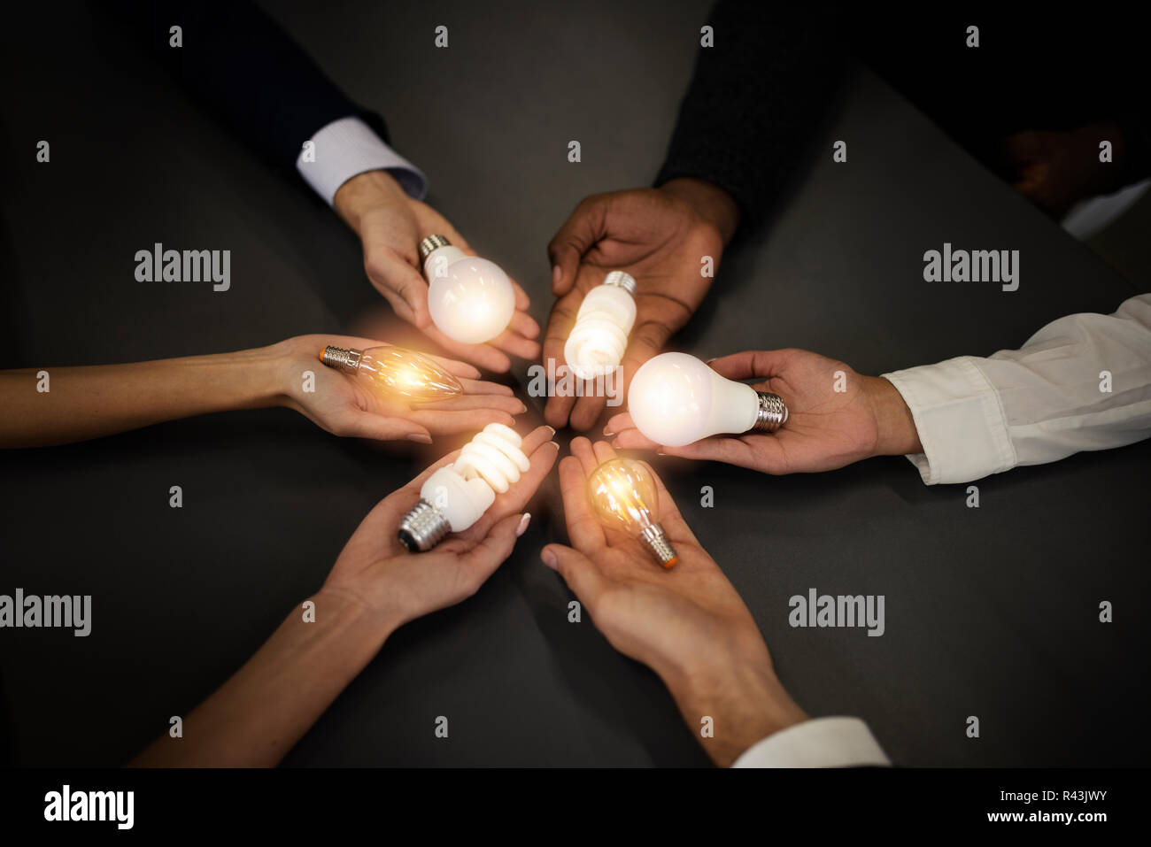 Il lavoro di squadra e il concetto di brainstorming con gli imprenditori che condividono un'idea con una lampada. Concetto di startup Foto Stock