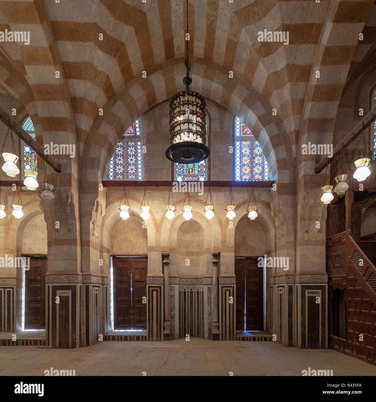 Parete di marmo con mihrab (Embedded di nicchia), due porte in legno, grandi archi, finestre di vetro colorato e un lampadario a moschea attaccata alla Bek Khayer Mausole Foto Stock