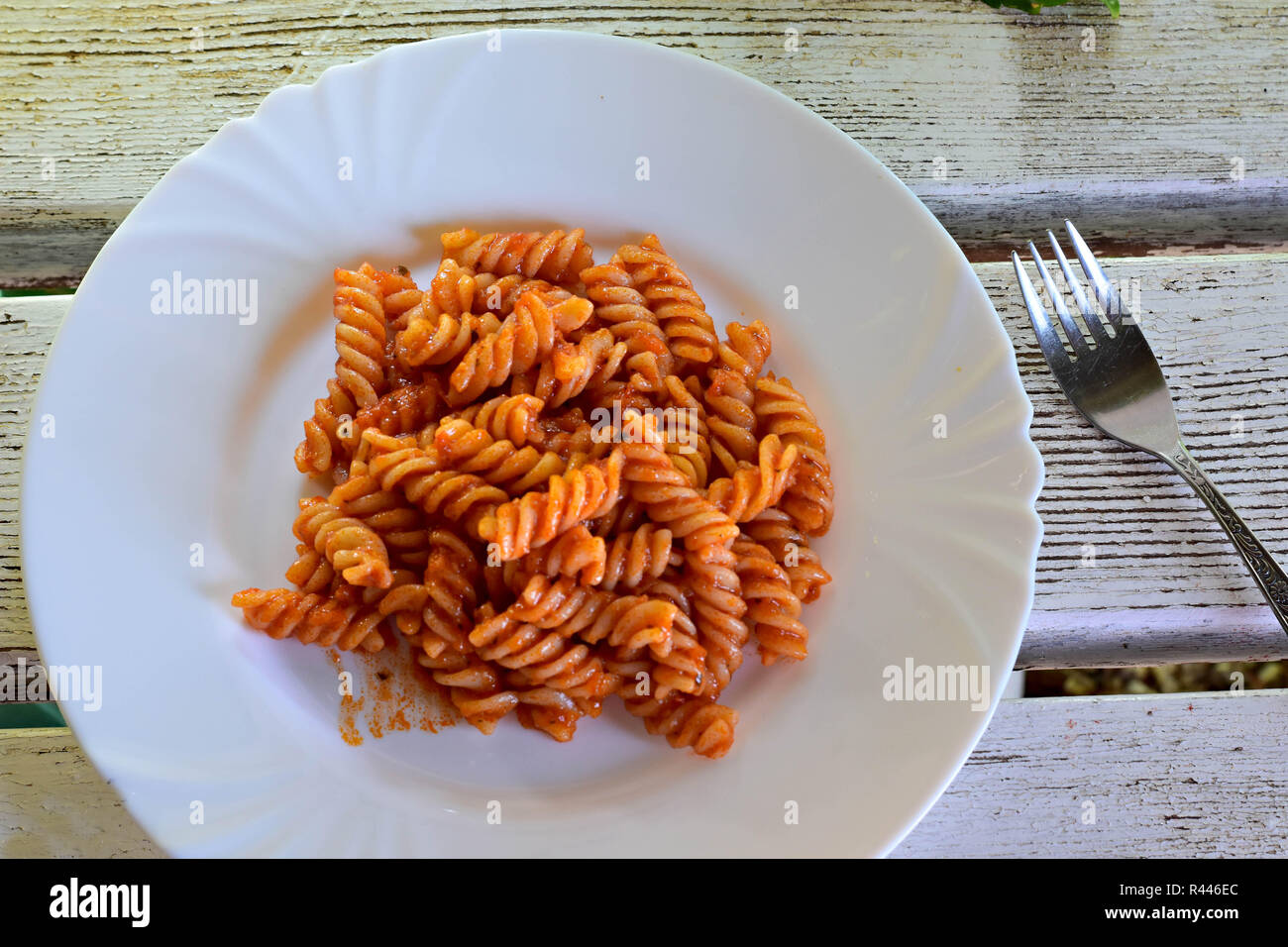 Deliziosa casa pasta intrecciata con salsa di pomodoro servita in corrispondenza della piastra in corrispondenza di luce sullo sfondo di legno/ cucina italiana Foto Stock