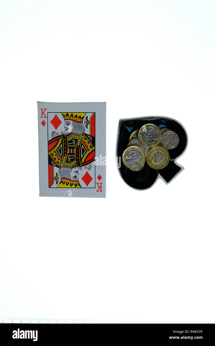 Pack di tradizionali carte da gioco su sfondo bianco con Ace of Spades gingillo a forma di ciotola per lato con cambio allentata in esso. Foto Stock