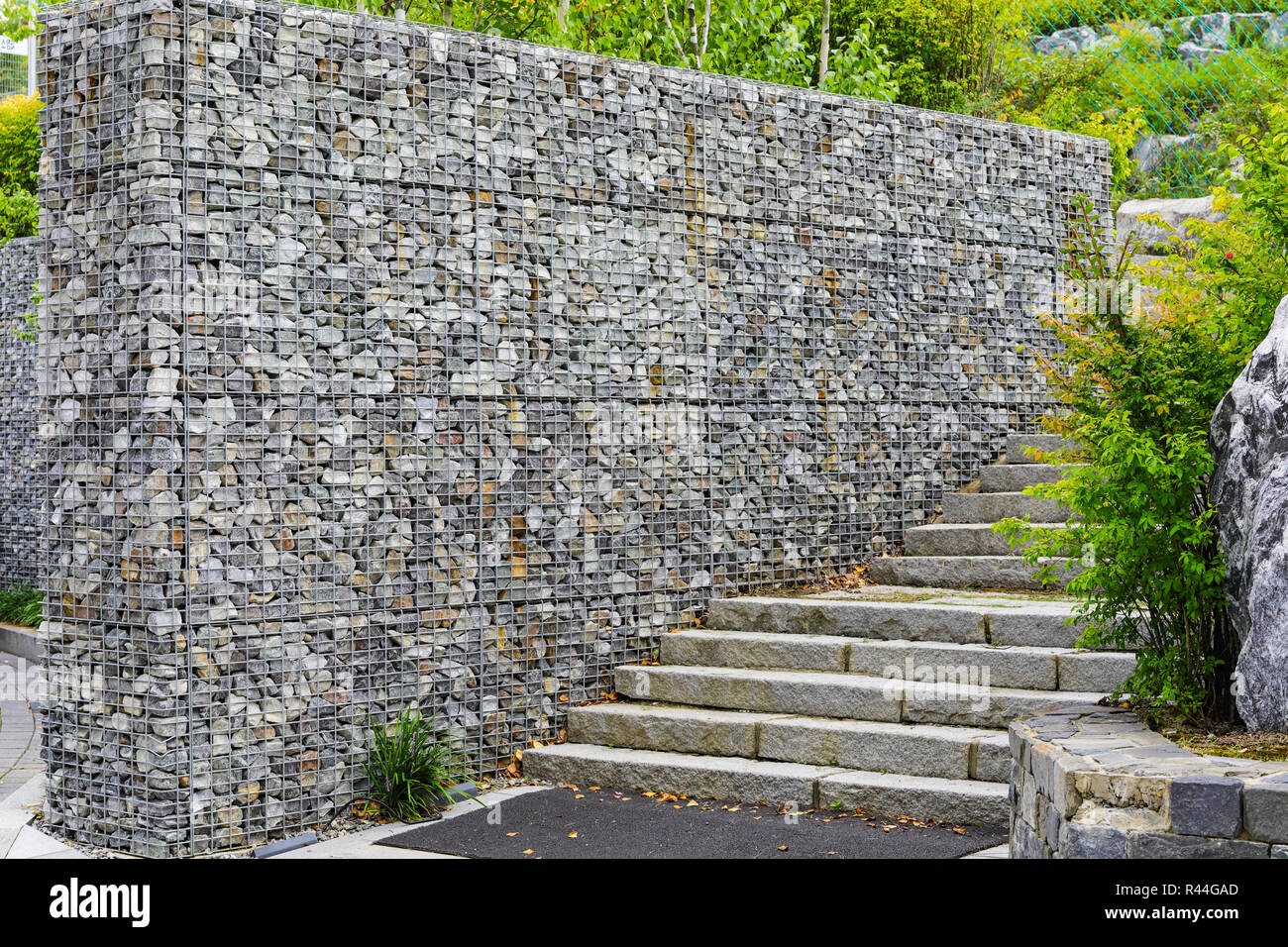 Muro di pietra con rete in acciaio Foto Stock