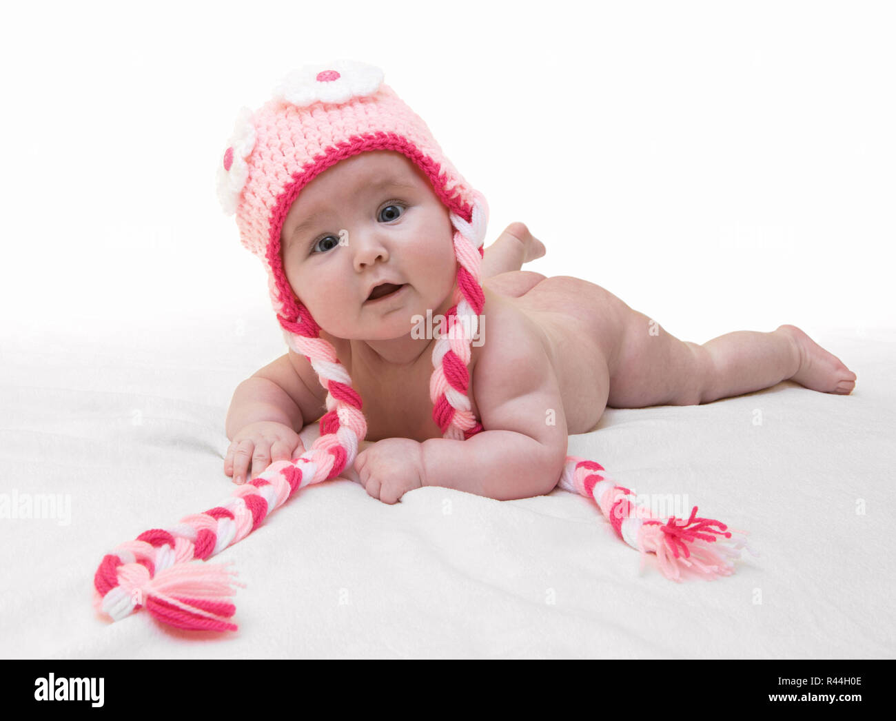 Funny femmina neonata con bella maglia rosa cappuccio su sfondo bianco.  Happy Baby girl con una bella maglia cappuccio colorato su coltre bianca.  Usura del neonato Foto stock - Alamy