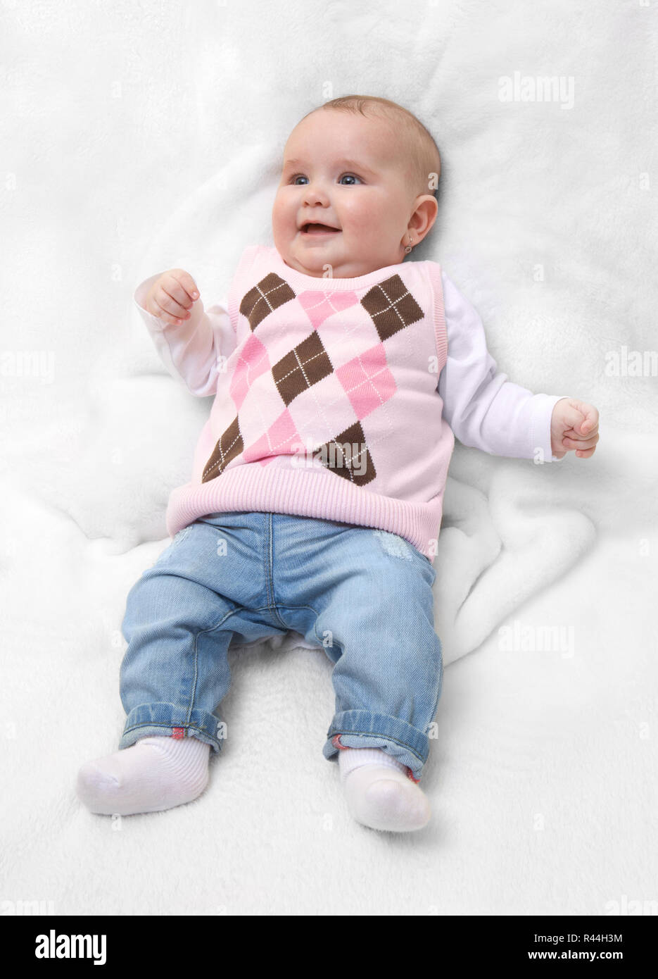 Divertente carino femmina neonata vestito in rosa maglione e jeans sulla  pelliccia bianca coperta. Bambino bambina con il rosa maglione e dei jeans  Foto stock - Alamy