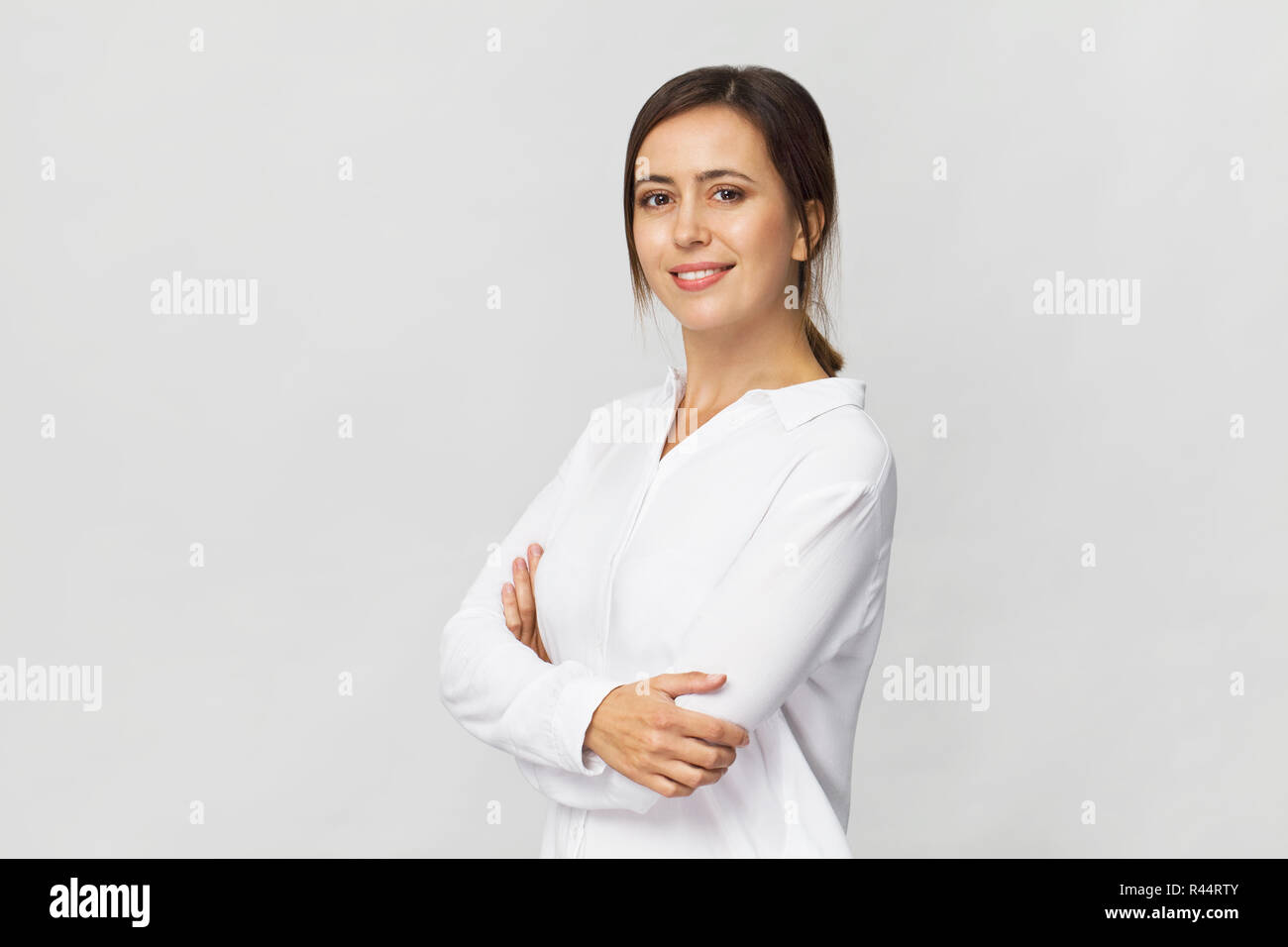 Imprenditrice ritratto in studio. La fiducia della donna in elegante camicia bianca isolata su bianco Foto Stock