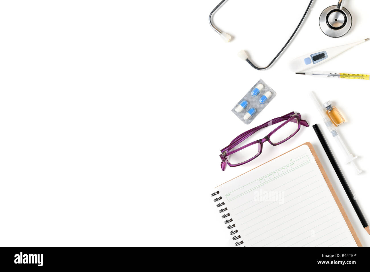 Notebook vuota con lo stetoscopio e accessori per medico isolato su sfondo bianco, assistenza sanitaria e il concetto di spazio di copia Foto Stock