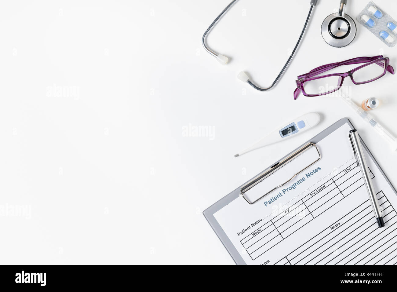 Il decorso del paziente nota con uno stetoscopio e accessori per medico sul tavolo bianco, Health care concept Foto Stock