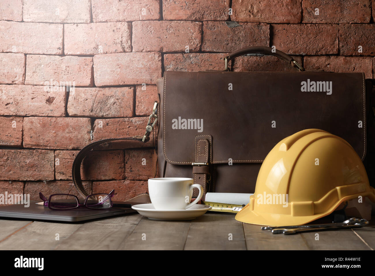 Vintage borsa in pelle con casco e l'attrezzo sul tavolo di legno,ingegnere o architetto concetto di occupazione Foto Stock