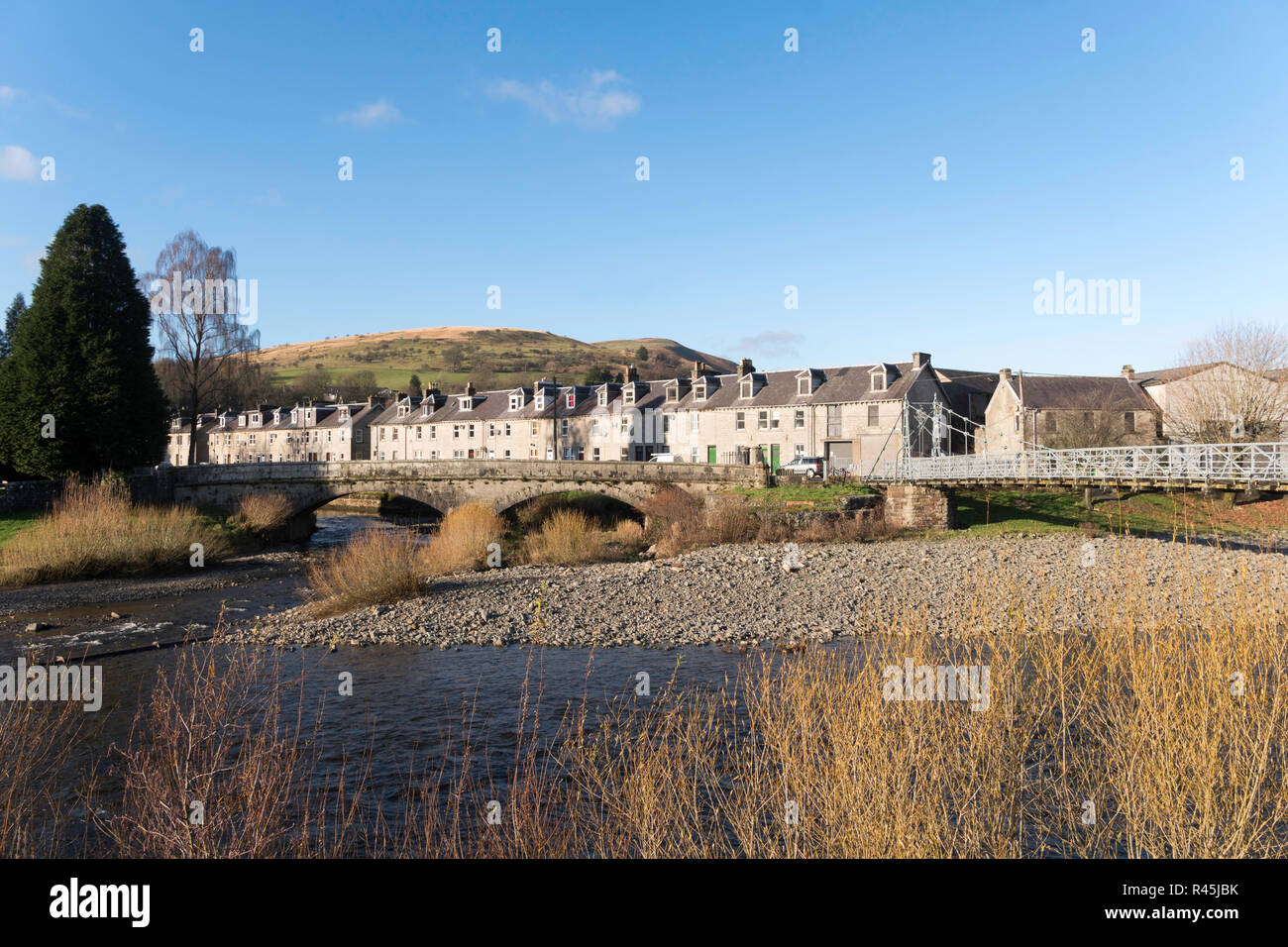 Punto di confluenza dei fiumi Esk e Wauchope acqua, con una fila di case dietro in Langholm, Dumfries and Galloway, Scotland, Regno Unito Foto Stock